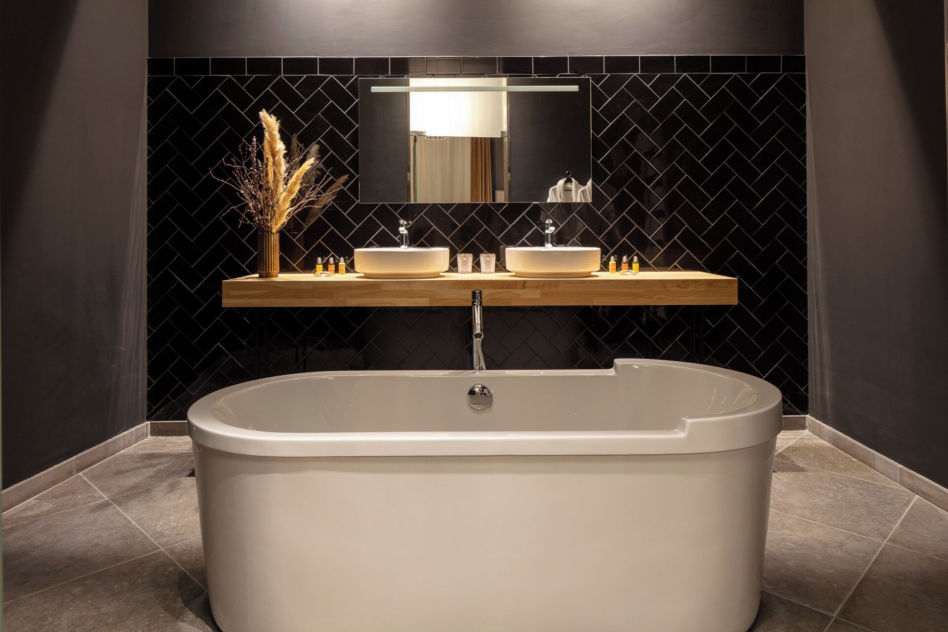 A modern bathroom with a freestanding bathtub, a vanity with two sinks, and a mirror above.