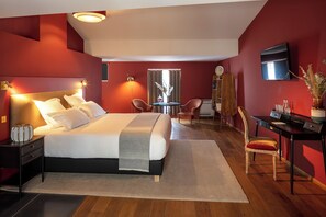 A modern hotel room with a large bed, a desk, a chair, and a TV. - Margaret - Hôtel Chouleur (Nîmes)