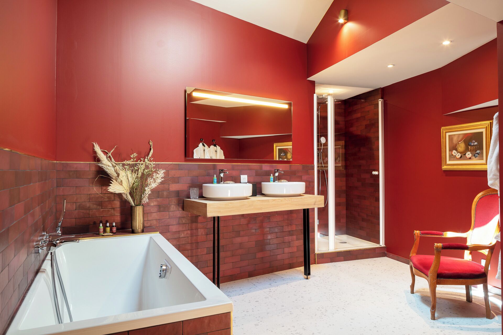 Un baño moderno con una bañera grande, dos lavamanos, un espejo y una ducha.