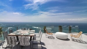 An outdoor dining area with a panoramic ocean view, featuring a wooden table with chairs and a round white ottoman. - VILLA MARGARIT (Rosas / Roses)
