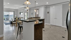 A spacious kitchen with a central island, pendant lighting, and a view to the outside.
