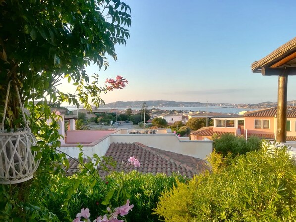 A residential area with a view of the sea, houses with red-tiled roofs, and lush greenery. - Vacation home in Palau, 5 min to the beach, next to the national park  (Palau)