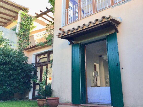 A building with a green door, a balcony with metal railings, and a tiled roof. - Vacation home in Palau, 5 min to the beach, next to the national park  (Palau)