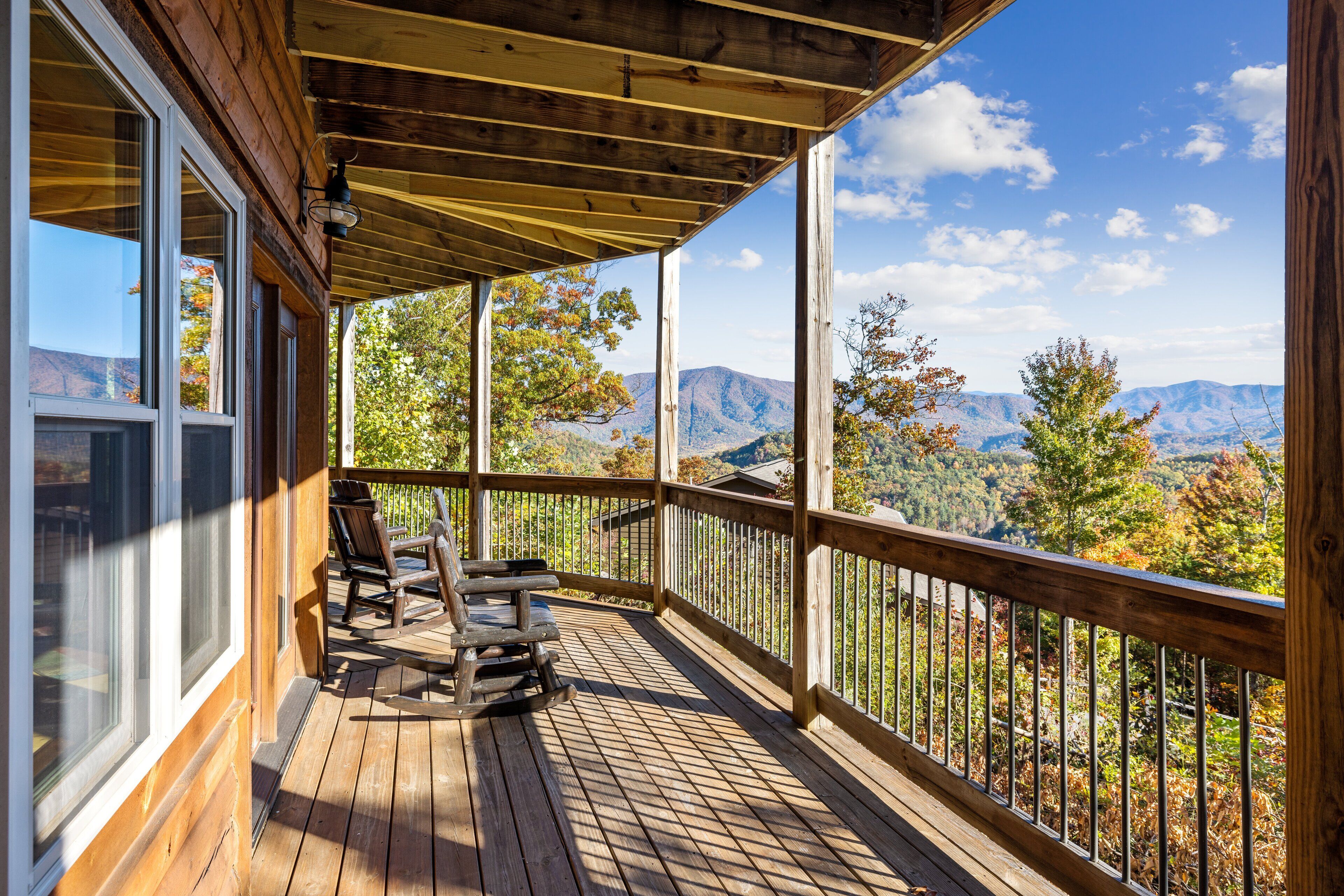 A wooden deck with a view of mountains and trees.