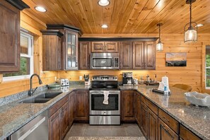 Eine moderne Küche mit Granit-Arbeitsplatten, Edelstahlgeräten und Holzschränken.