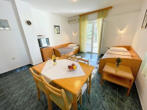 Cozy retreat with a single bed, sofa bed, and dining area, perfect for a relaxing stay.