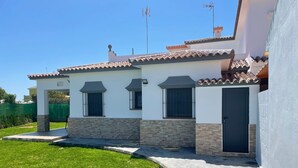 Una casa de dos plantas con techo de tejas, un porche cubierto y un camino de entrada pavimentado.