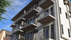 A multi-story building with balconies, large windows, and a modern architectural design.