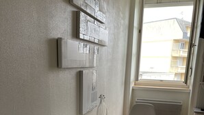 Una cocina moderna con una mesa y una silla blancos, y una ventana con vistas a edificios.