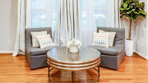 A living room with two grey sofas, a round coffee table, and a potted plant. - 3000 sq feet house- Braves, Coke, Barbie Themed Rooms next to Truist Park (Marietta)