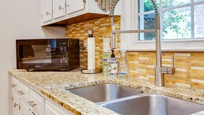 A kitchen with granite countertops, stainless steel sink, and a microwave. - 3000 sq feet house- Braves, Coke, Barbie Themed Rooms next to Truist Park (Marietta)
