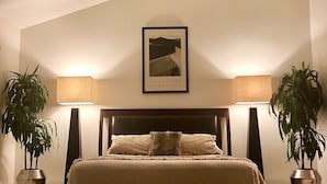 A bedroom with a bed, two bedside lamps, a ceiling fan, and two potted plants. - Townhouse Located Near Frontier Park and the Capitol Building (Cheyenne)