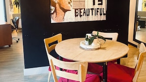 A dining area with a round table, chairs, and a wall mural with the text "LIFE IS BEAUTIFUL". - Townhouse Located Near Frontier Park and the Capitol Building (Cheyenne)