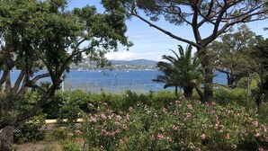 A garden with a view of the sea, featuring trees and flowering shrubs. - Large charming Bastide- private pool- Air conditioning- WIFI-1.2 km from St Tropez-Vue Mer (GASSIN)