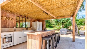 An outdoor kitchen with a wooden bar, bar stools, and a grill. - Large charming Bastide- private pool- Air conditioning- WIFI-1.2 km from St Tropez-Vue Mer (GASSIN)