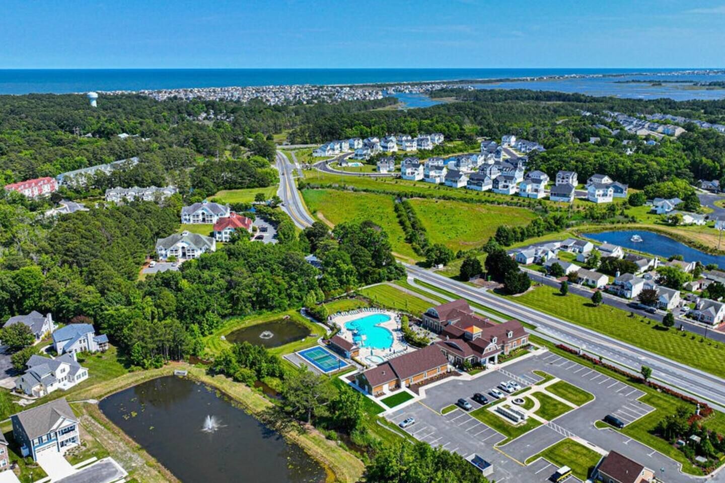 Ein Luftbild eines Wohngebiets mit Häusern, einem Schwimmbad und einer Straße.