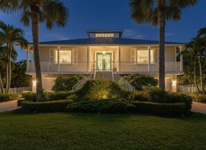 A two-story house with a balcony, a front door, and a well-maintained lawn. - Waterfront Key West Retreat |Heated Pool| Dock|BBQ (Marco Island)