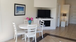 A modern kitchen with white cabinetry, a built-in oven, and a flat-screen TV above the oven.