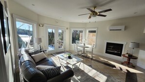A spacious living room with a leather sofa, a dining table, and a fireplace.
