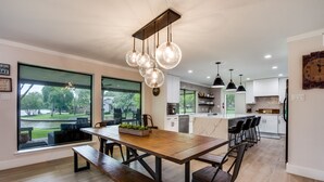 Una cocina moderna con comedor, ventanas amplias y vistas al exterior.