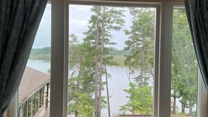 A room with a large window overlooking a lake and trees. - Perfect relaxing lake retreat for hosting a gathering. Quiet with no neighbors. (Westminster)