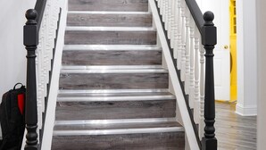 A staircase with wooden steps and black balusters, leading to an upper floor. - Remodeled luxury with Proximity (Lewisville)