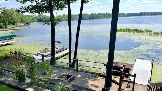 A lakeside deck with a boat dock, seating area, and a small garden. - Home w/ hot tub, game room, sauna on Lake Wausau near Granite Peak (Schofield)