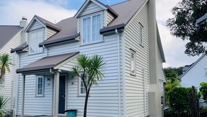 Een twee verdiepingen tellend huis met een voortuin, een kleine tuin en een zichtbare garage.