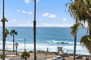 A coastal view with palm trees, a lifeguard tower, and a clear sky. - Spacious Beach House • Walk to Beach, Pier & Downtown (Oceanside)