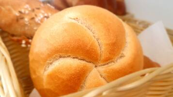 Una cesta con hogaza de pan con diseño en forma de cruz.