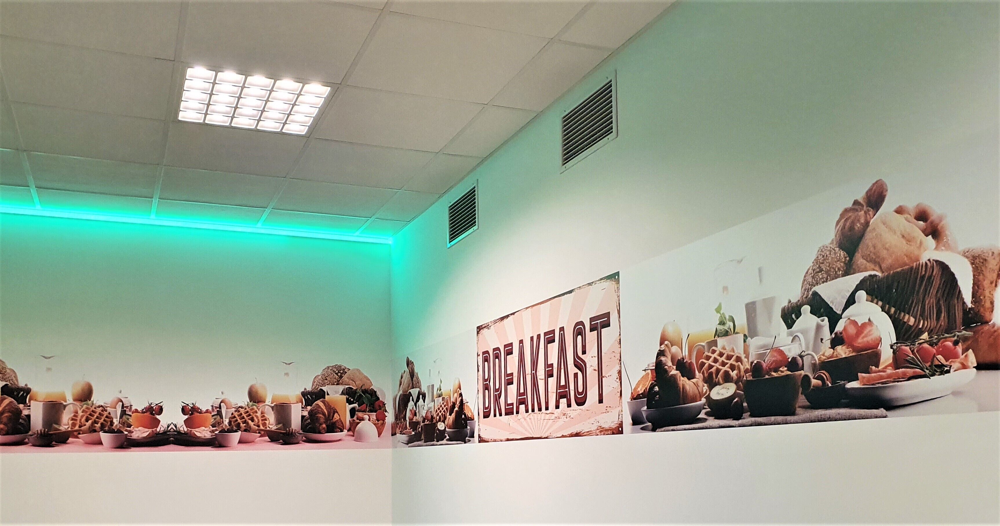 A breakfast buffet with various food items and a sign that reads "BREAKFAST".