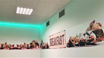 A breakfast buffet with various food items and a sign that reads "BREAKFAST".