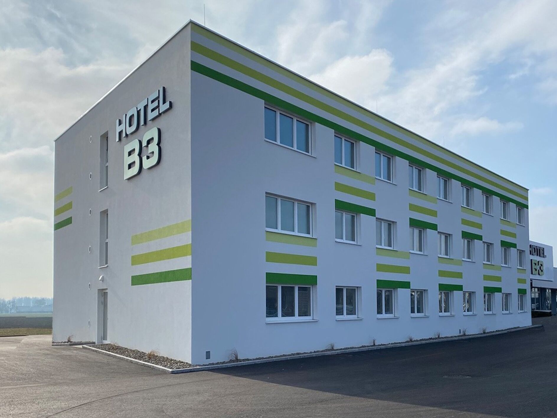 A modern hotel building with a sign reading "HOTEL B3".
