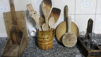 Una encimera de cocina con varios utensilios de madera, incluyendo un juego de cucharas de madera, una espátula de madera y un rallador de madera.