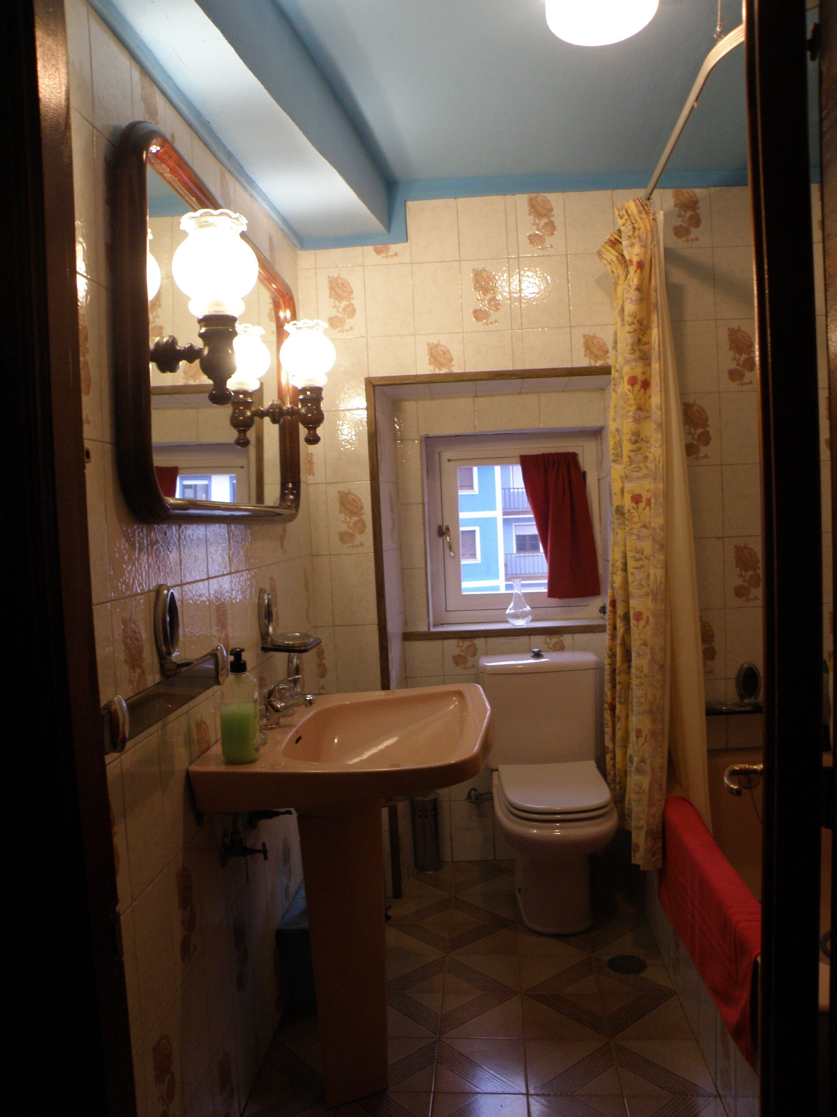 Een badkamer met een wastafel, toilet en douche.