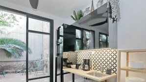Een moderne keuken met een groot raam, een inbouwoven en een koffiezetapparaat.
