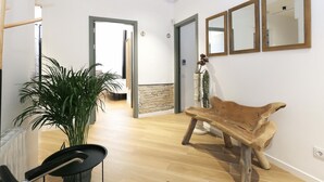 Ruime kamer met een houten salontafel, een potplant en een modern design met een stenen accentmuur.
