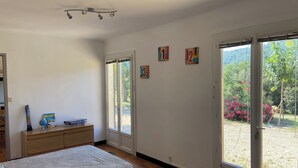 A bedroom with a bed, a dresser, and a window with a view of greenery. - Quiet wine-growing estate in the heart of nature, ideal for family vacations (Brignoles)