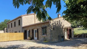 A two-story stone house with a tiled roof, a wooden fence, and a gravel driveway. - Quiet wine-growing estate in the heart of nature, ideal for family vacations (Brignoles)