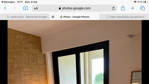 A hotel room with a bed, a nightstand, a lamp, a sliding glass door to a balcony, and a large mirror. - Elegant 3 rooms. Tennis pool and greenery. (Antibes)