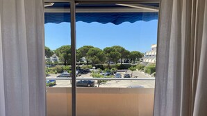 Un balcón con vista a un estacionamiento y árboles.