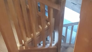 A wooden staircase with a handrail and a view of the outside. - Chalet in a small village in the Hautes Pyrénées close to walks and hikes (Bareilles)