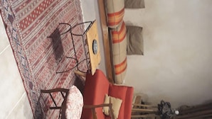 A kitchen with a stove, sink, and various kitchen utensils. There is a red chair and a patterned rug. - Chalet in a small village in the Hautes Pyrénées close to walks and hikes (Bareilles)