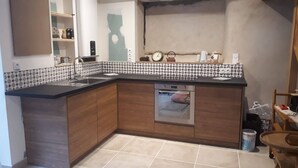 A kitchen with a built-in oven, a sink, and a tiled backsplash. - Chalet in a small village in the Hautes Pyrénées close to walks and hikes (Bareilles)