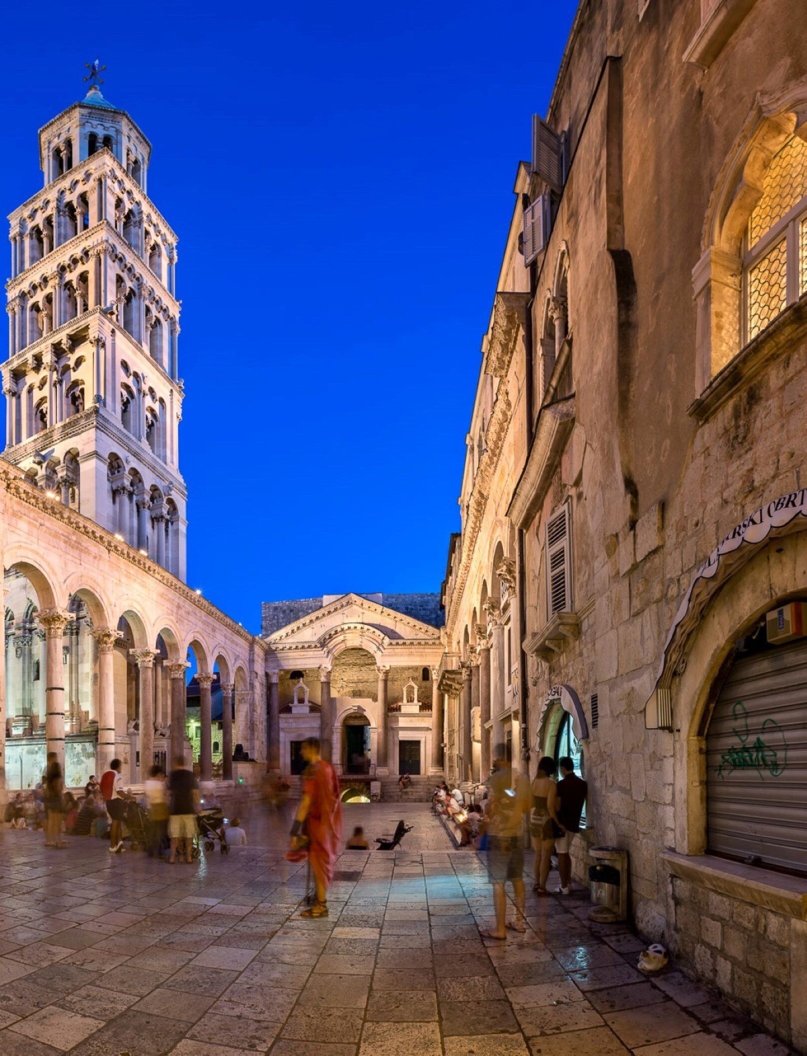 A historic square with a prominent bell tower and classical architecture.