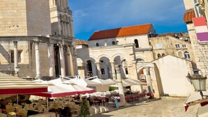 A historic square with a prominent tower, cobblestone pavement, and outdoor seating areas. - A1 - apt in the Very Heart of Split With sea View (Split)