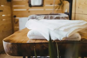 A wooden table with a glass bowl and a folded white towel. - Lovely Cottage With sea Views in Selca, Croatia (Selca)