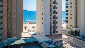 Ein Hochhaus-Hotel mit Balkonen mit Blick auf einen Strand.