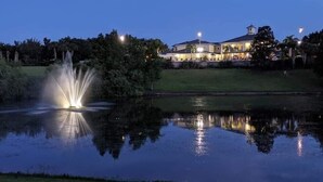 A large building with a prominent tower, reflecting in a calm body of water. - Chic Disney Condo/w Fireplace at Bahama Bay Resort 15 mins from Disney  (Davenport)