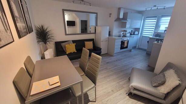 Un appartement moderne comprenant un coin repas, un canapé, une cuisine et un salon.